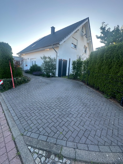 Ein modernes, zweistöckiges Einfamilienhaus mit gepflegtem Garten in einer ruhigen Wohngegend.